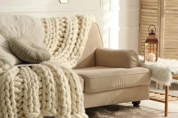 Gemütlicher Sessel mit Strickdecke